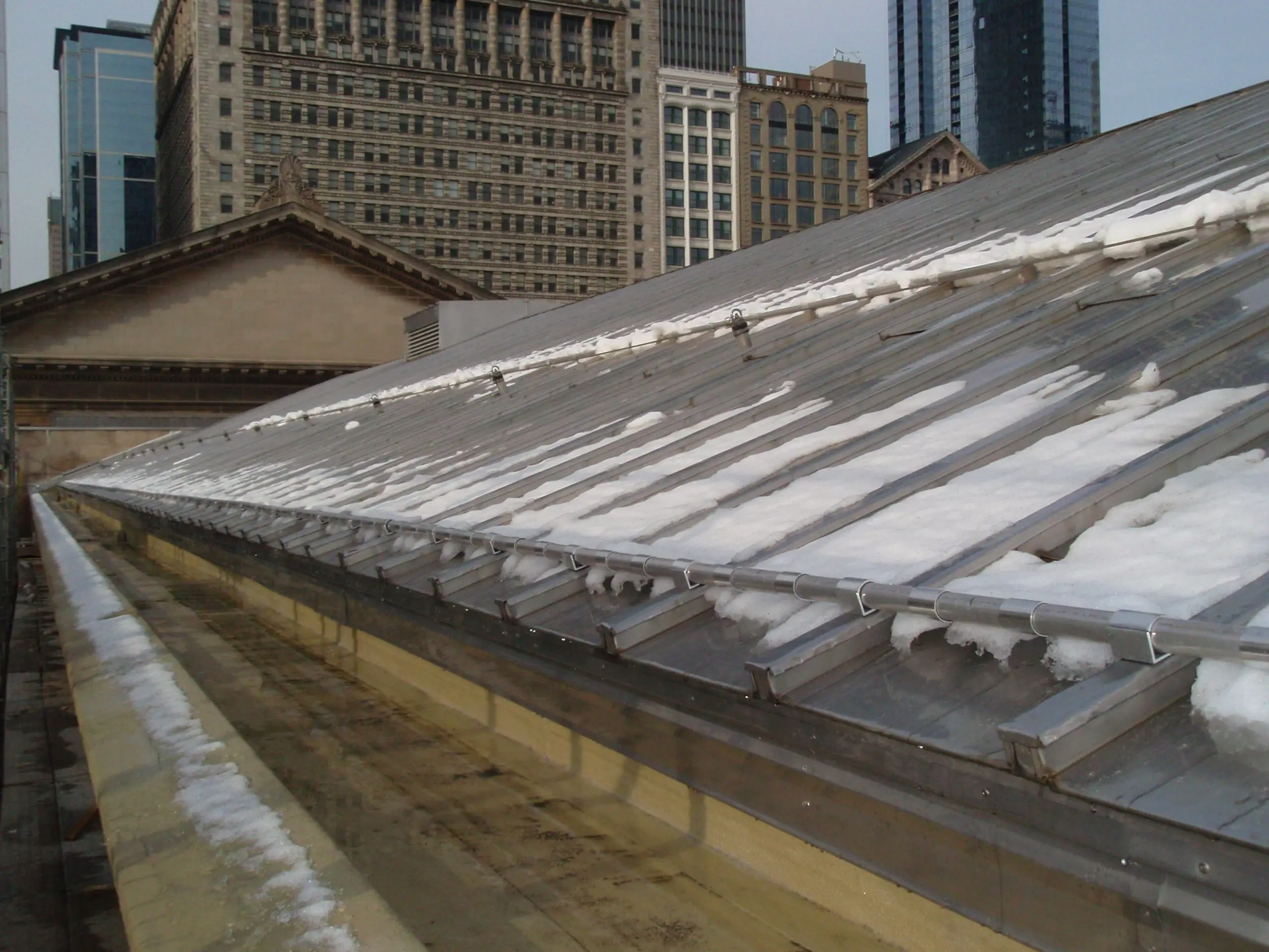 Snow guards for batten seam roofs